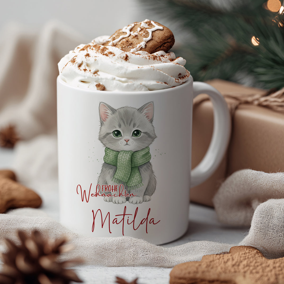 Tasse mit grauer Katze, grüner Schal und Weihnachtsgruß.