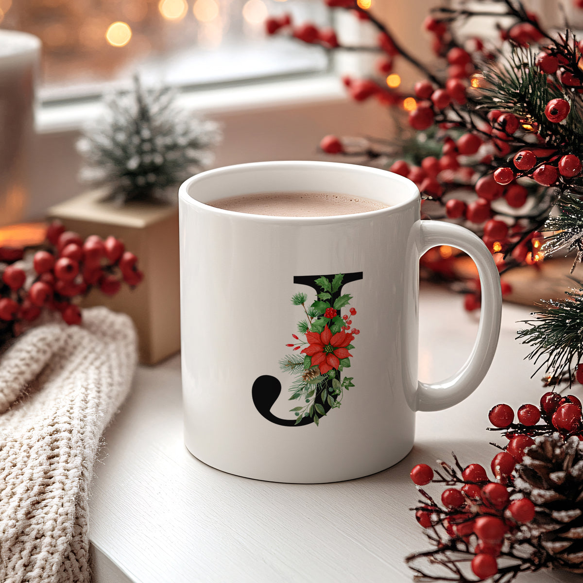 Weißer Becher mit floralem "J"-Design und heißem Getränk.