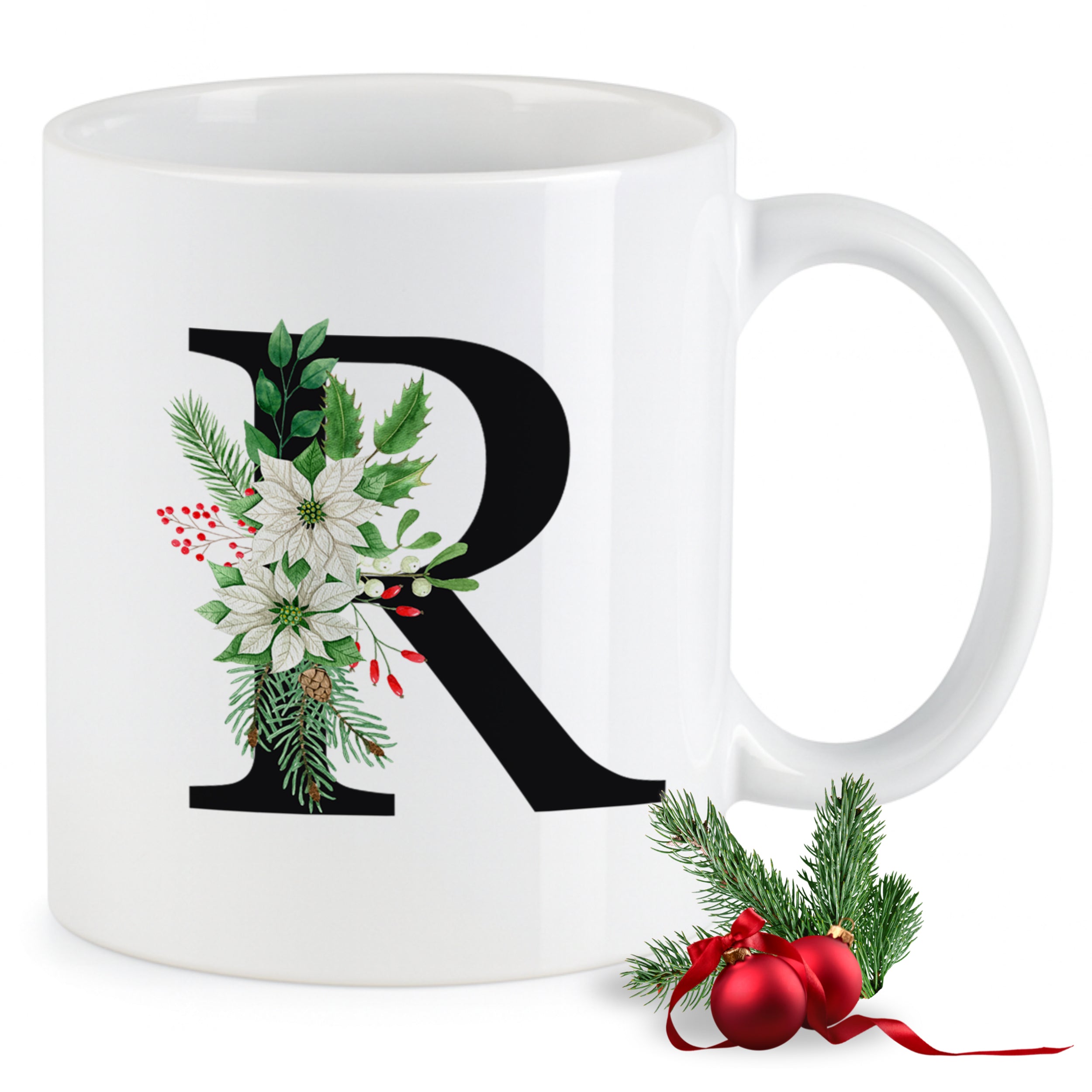 Weiße Tasse mit floralem Buchstaben R und Weihnachtsdekor.