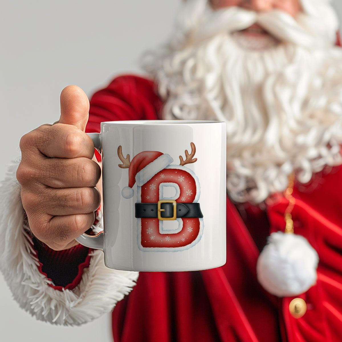 Weißer Becher mit rotem "B" und Weihnachtsmotiven.