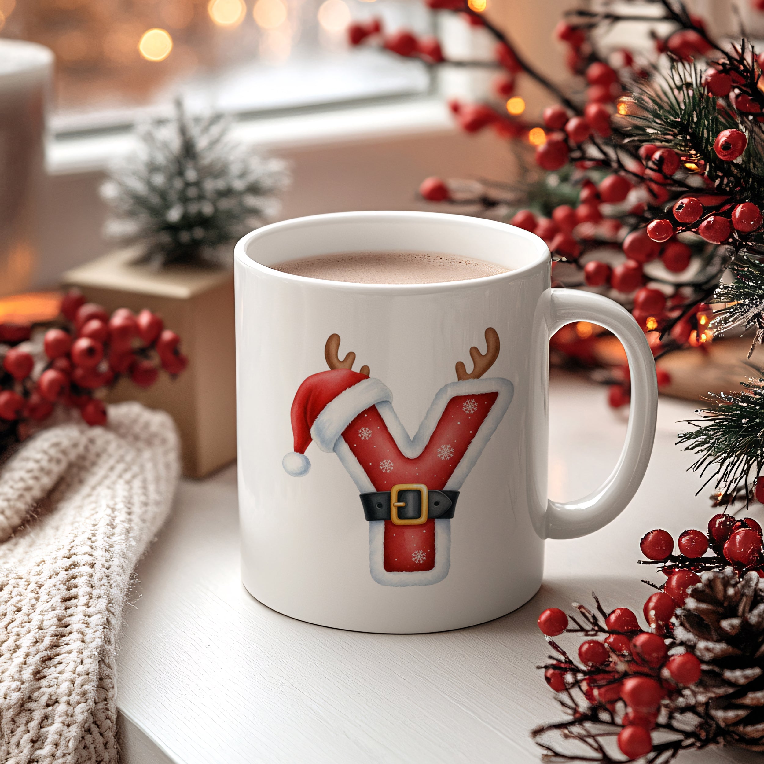 Weißer Becher mit rotem Weihnachtsbuchstaben Y und Dekoration.