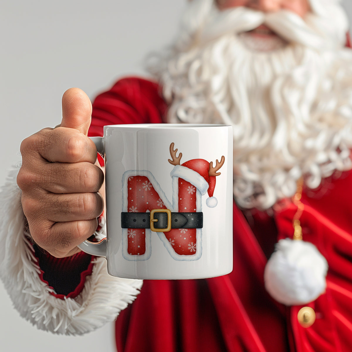 Weihnachtstasse mit rotem "N", Rentier und Weihnachtsmütze.