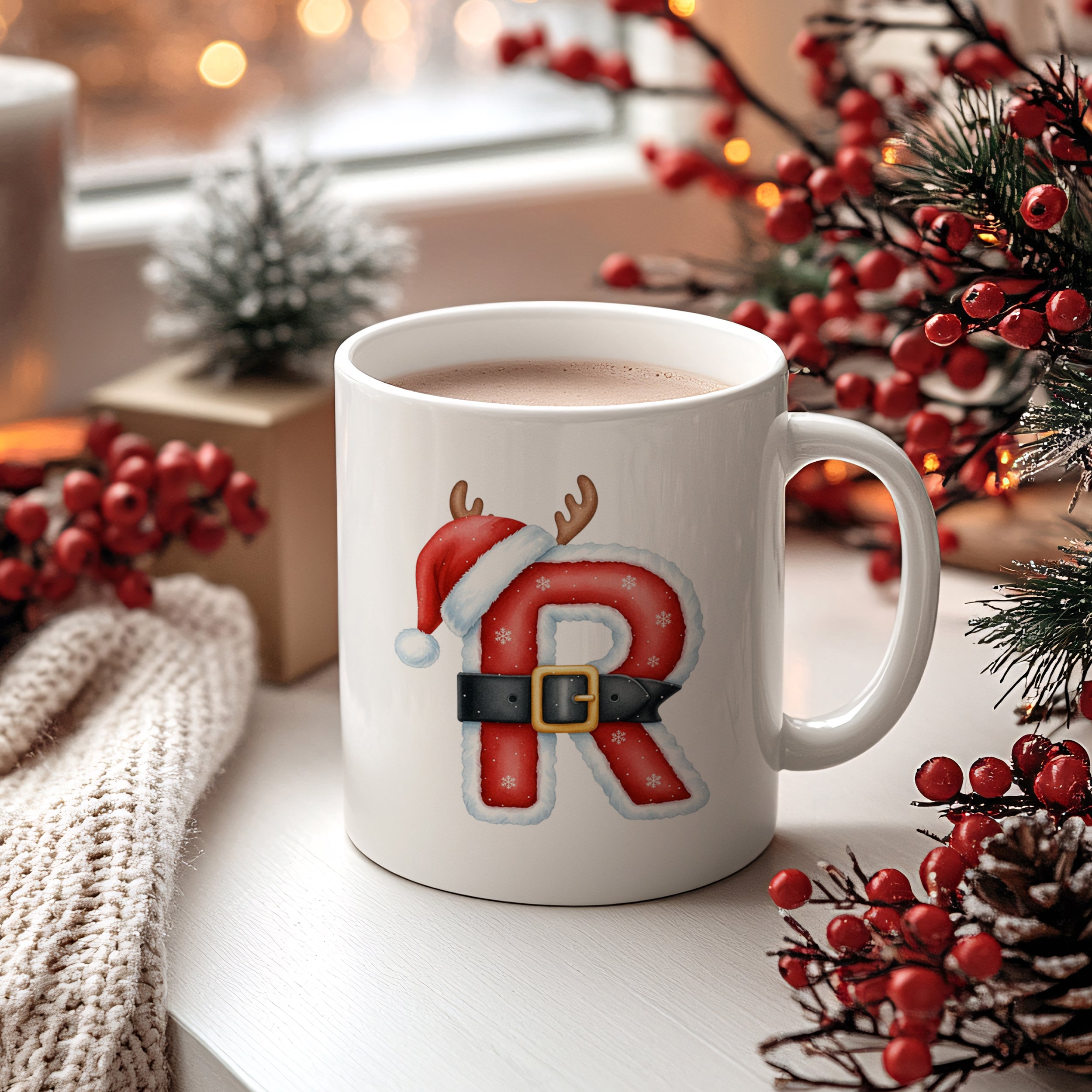 Weißer Becher mit rotem "R", Weihnachtsmütze und Rentiergeweih.