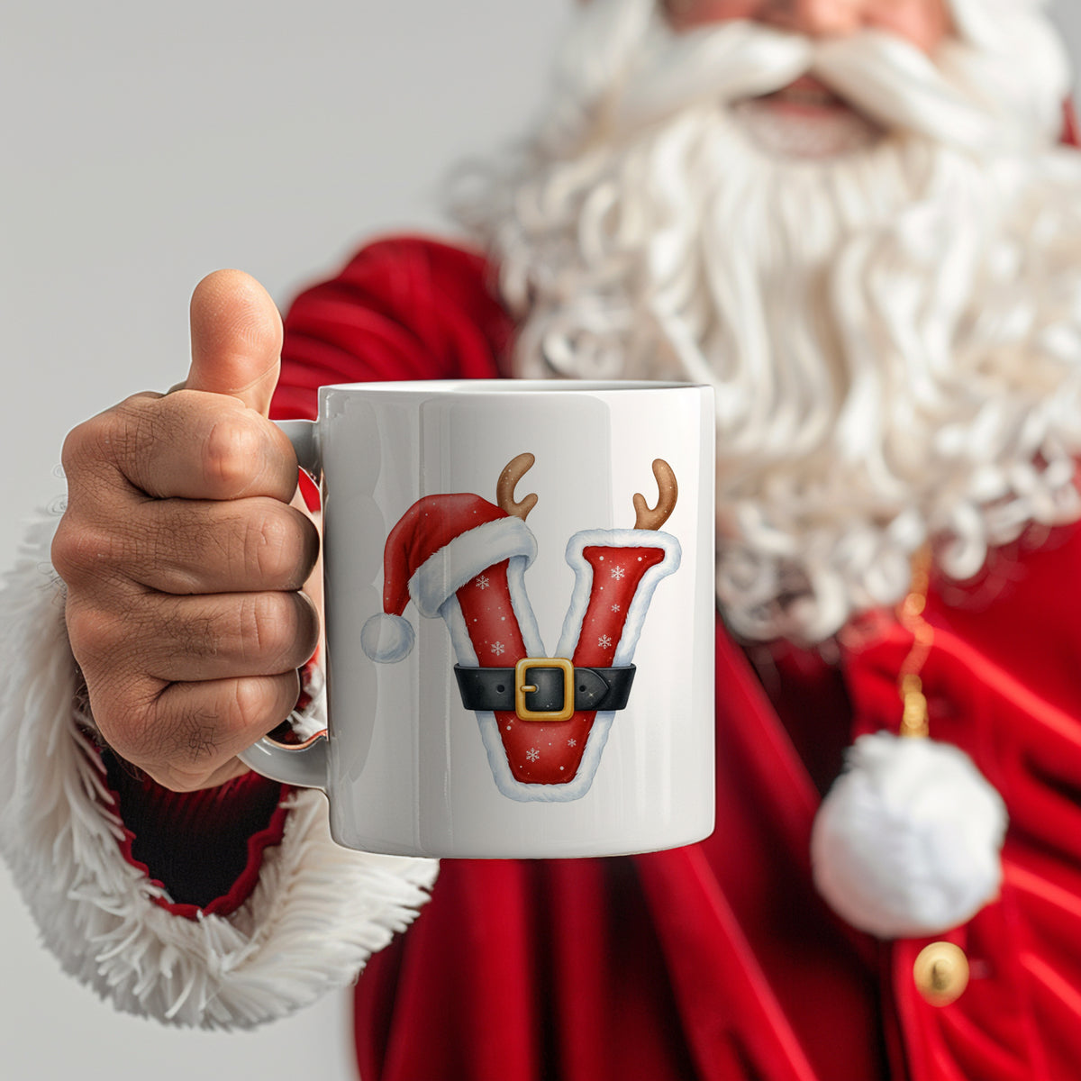 Weißer Weihnachtsbecher mit rotem "V" und Weihnachtsmotiven.