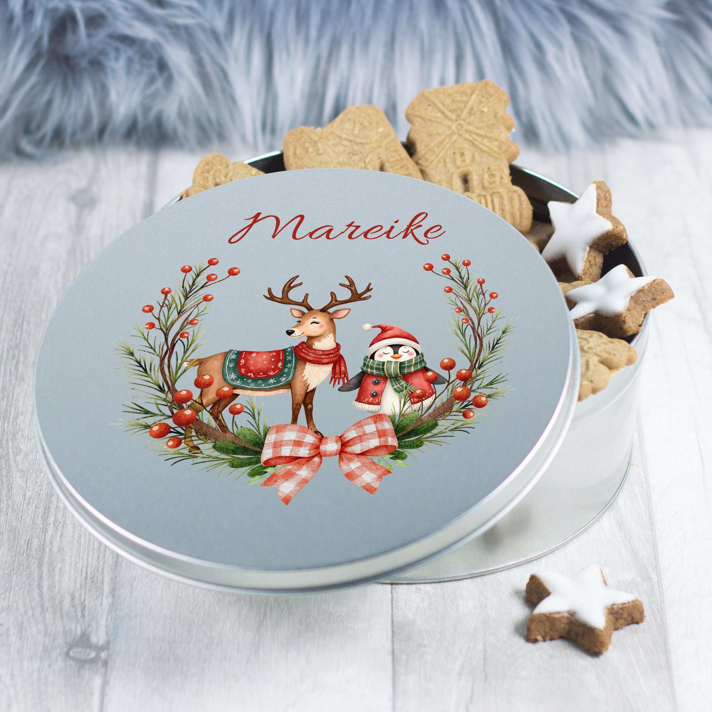 Runde, graue Keksdose mit Rentier und Schneemann-Motiv.