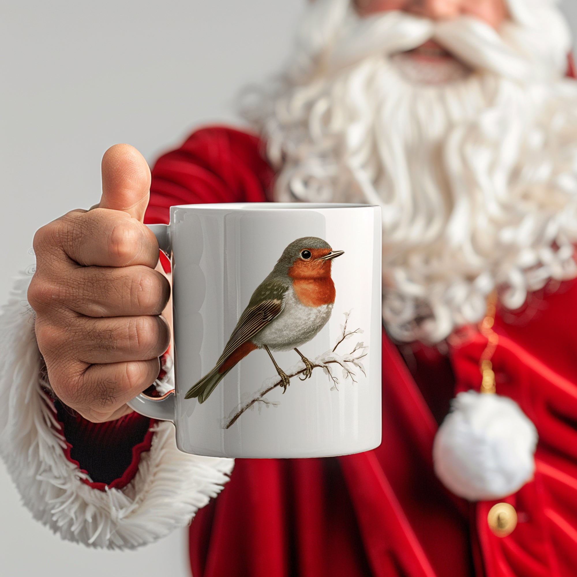 Tasse mit Rotkehlchen-Motiv, weiß, von Weihnachtsmann gehalten.