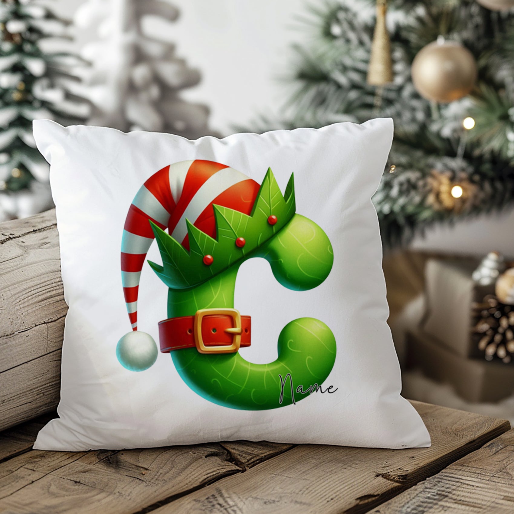 Weihnachtliches Kissen mit grünem Buchstaben C und Hut.