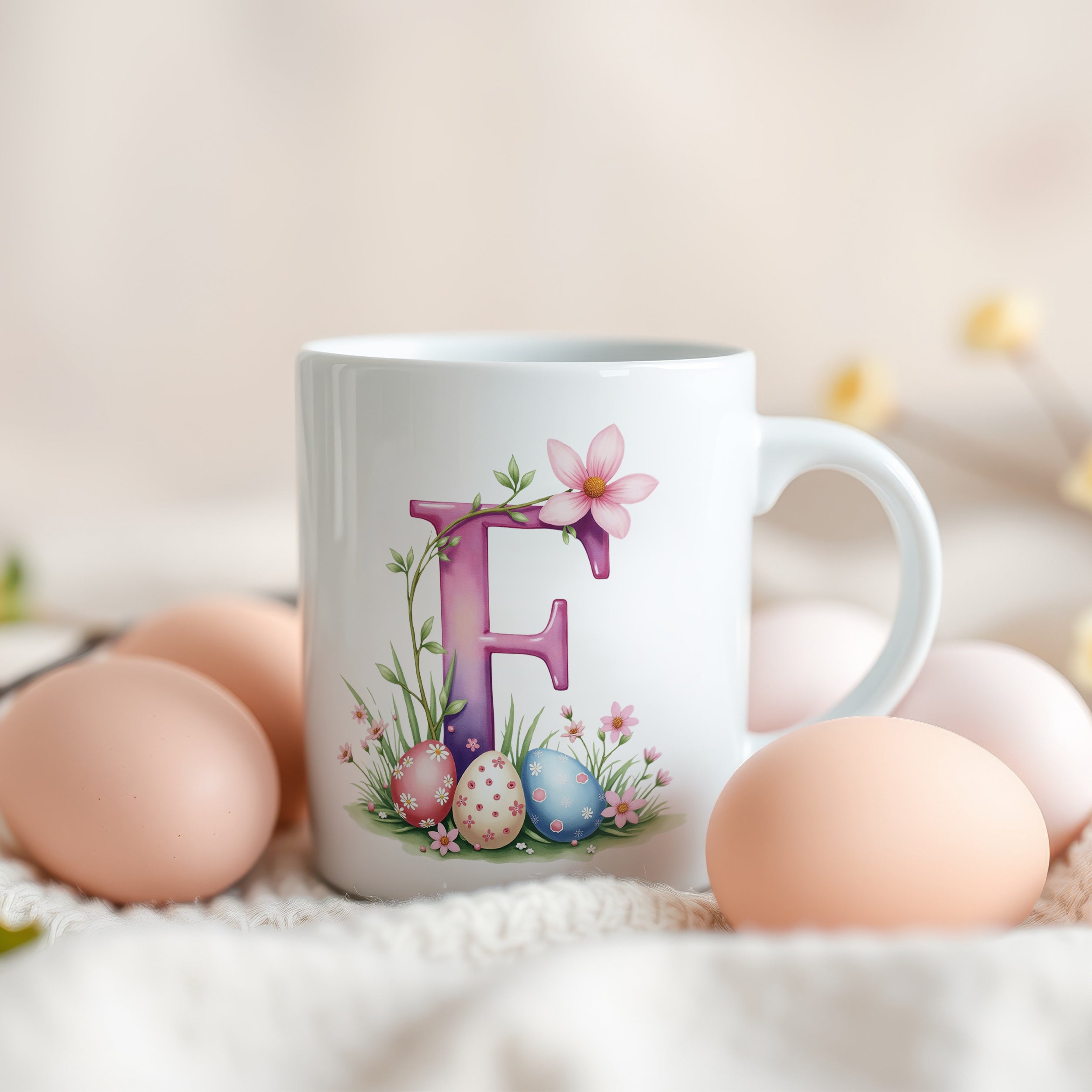 Weiße Tasse mit buntem Buchstaben F und Ostereiern.