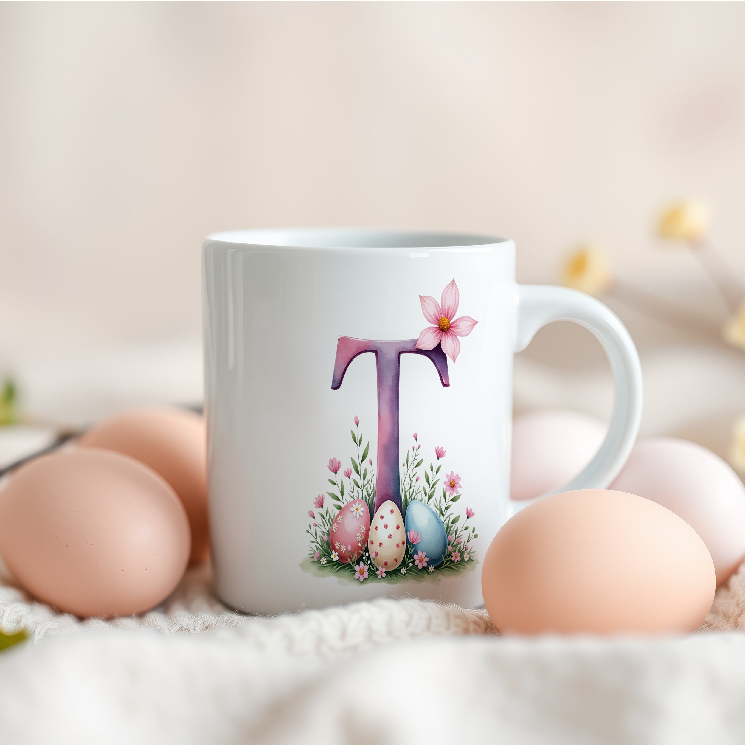 Weiße Tasse mit floralem Design und Buchstabe T.