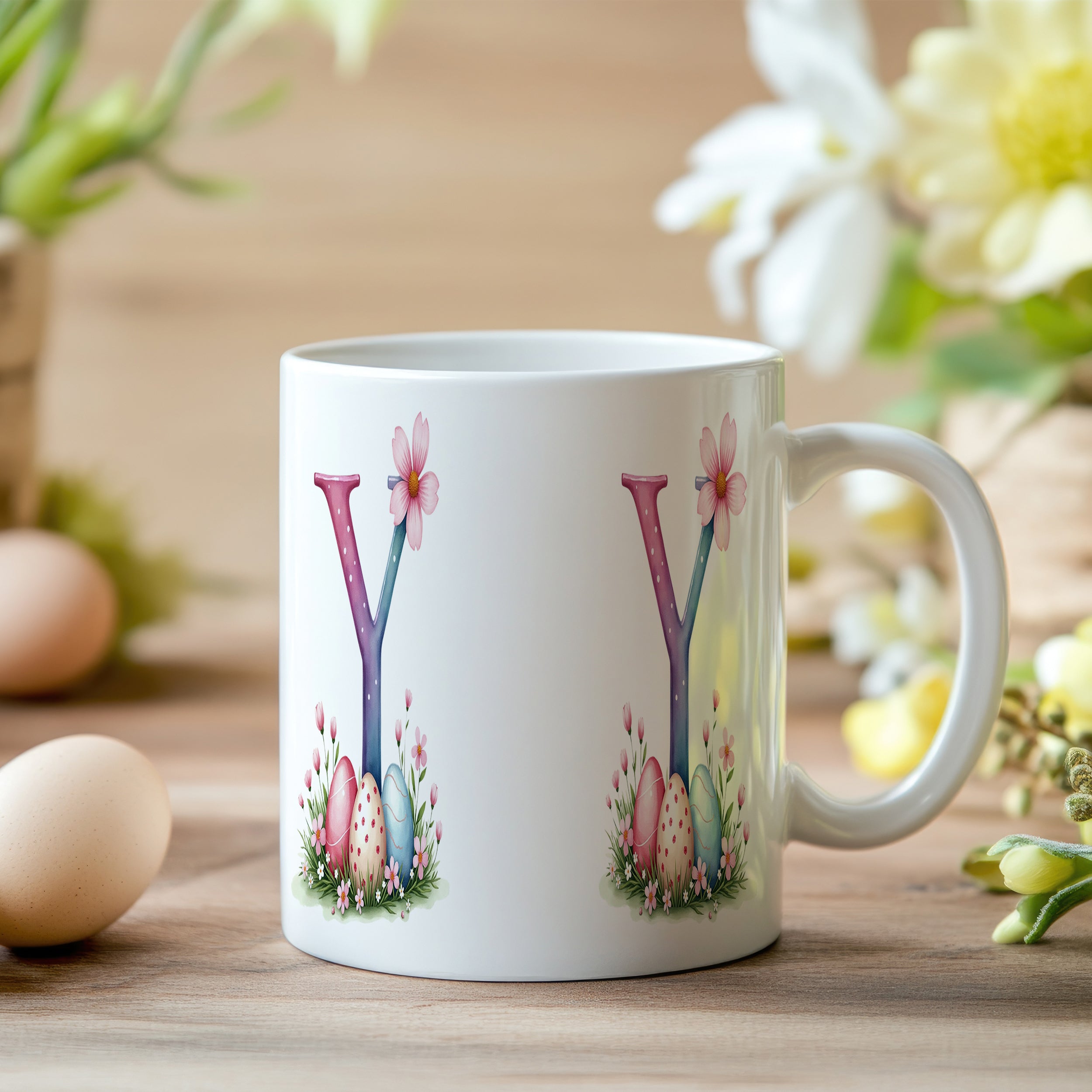 Weißer Kaffeebecher mit buntem Osterdesign und Blumen.