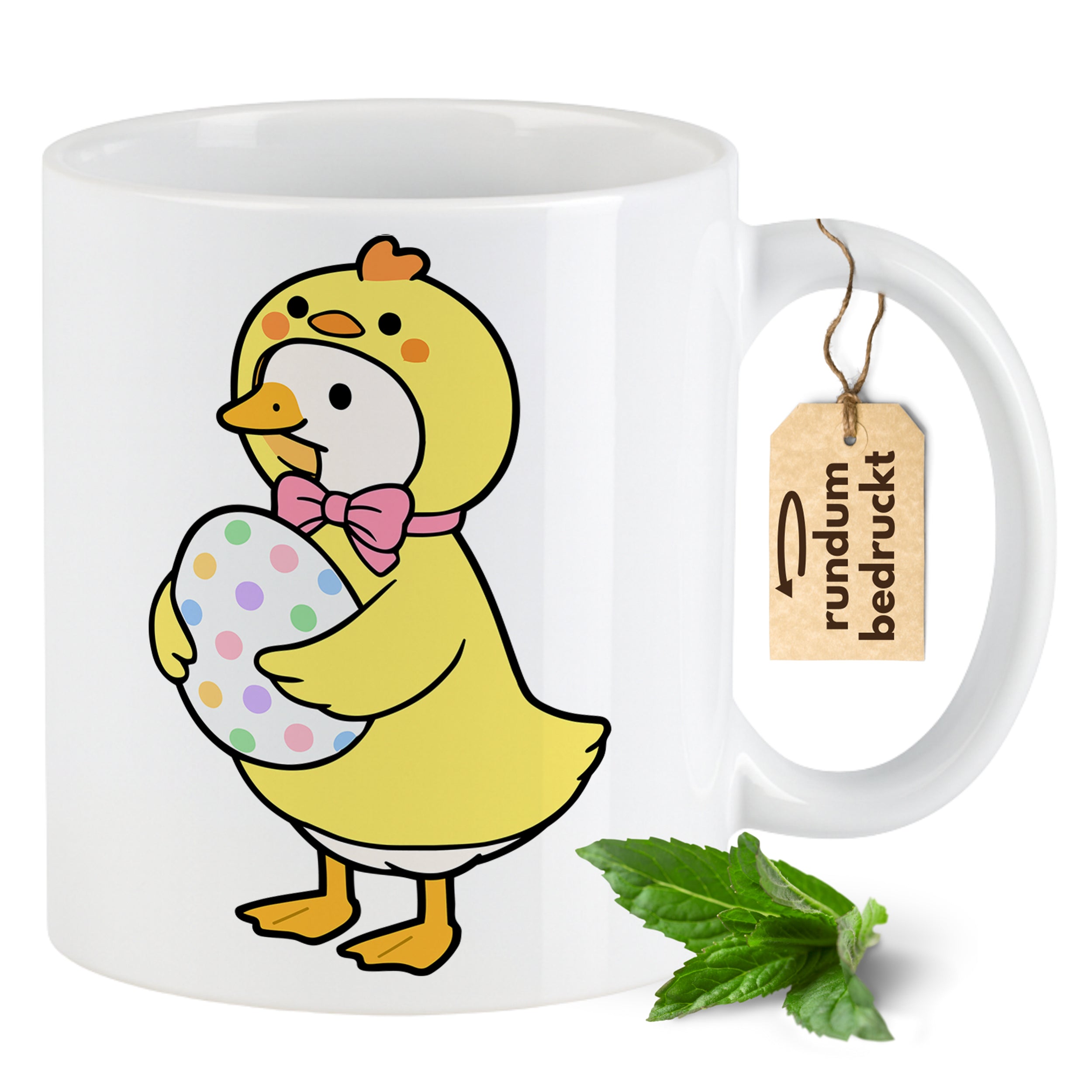 Kaffeetasse mit gelber Ente, pinker Schleife und buntem Ei.