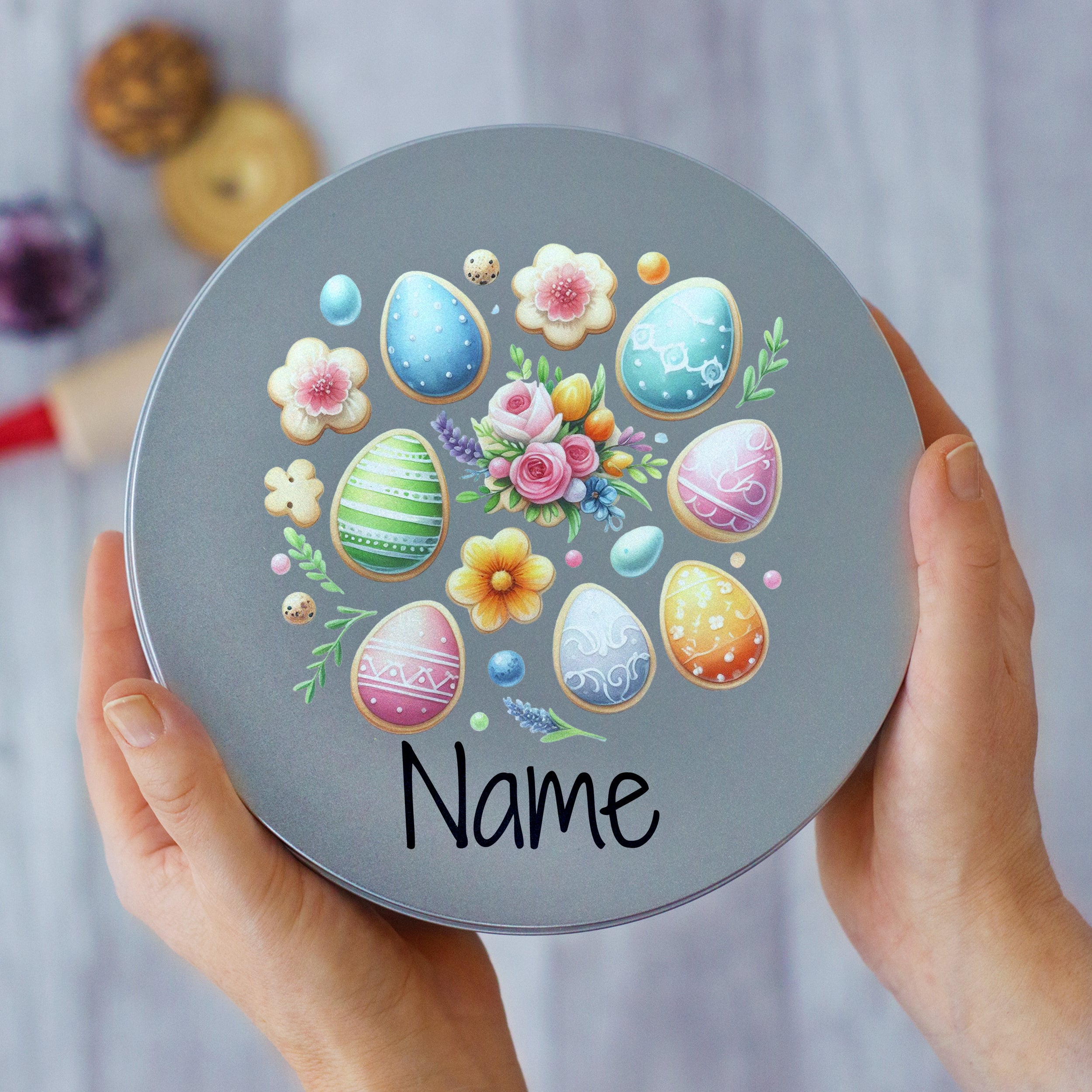 Bunte Ostereier auf grauer Dose mit Blumenmotiv.
