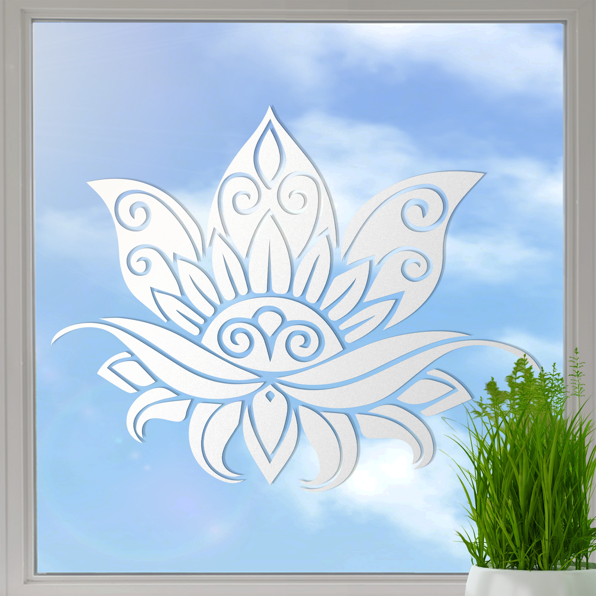 Weißes Fensterdekor mit Lotusblumen-Motiv vor blauem Himmel.