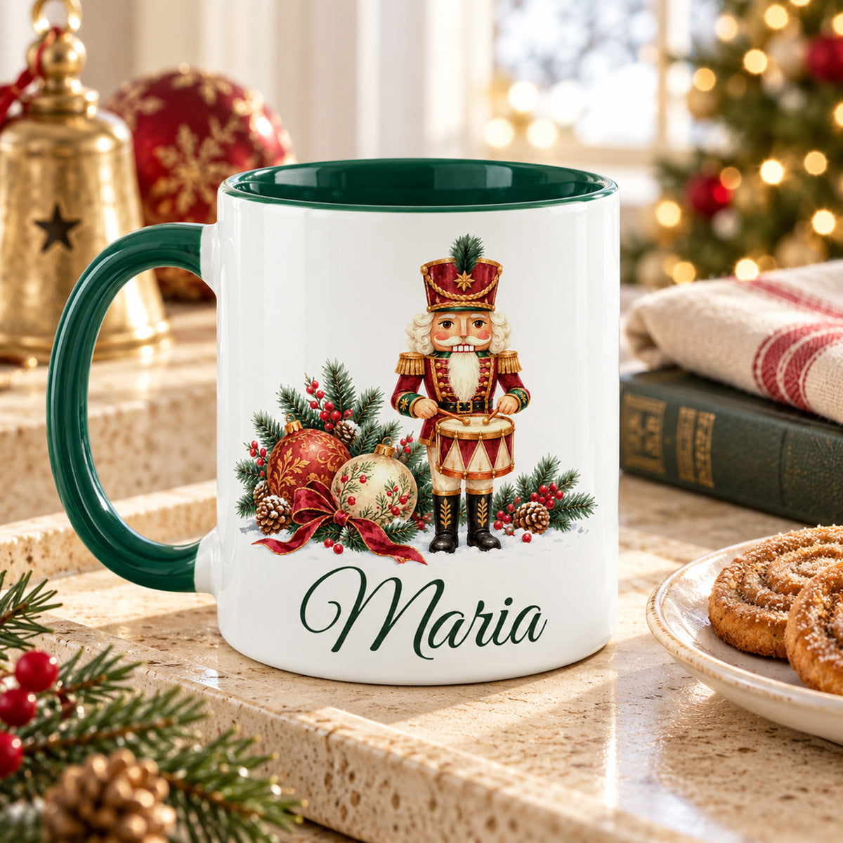 Weiße Keramiktasse mit grünem Henkel und grüner Innenseite, Motiv Festlicher Trommler und Wunschname auf einem Tablett mit Gebäck in weihnachtlicher Umgebung.