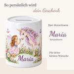 Namenspersonalisierung auf einer Keramikspardose mit einer Fee, einem Einhorn und einer Blumenwiese; daneben ein vergrößerter Beispielschriftzug.