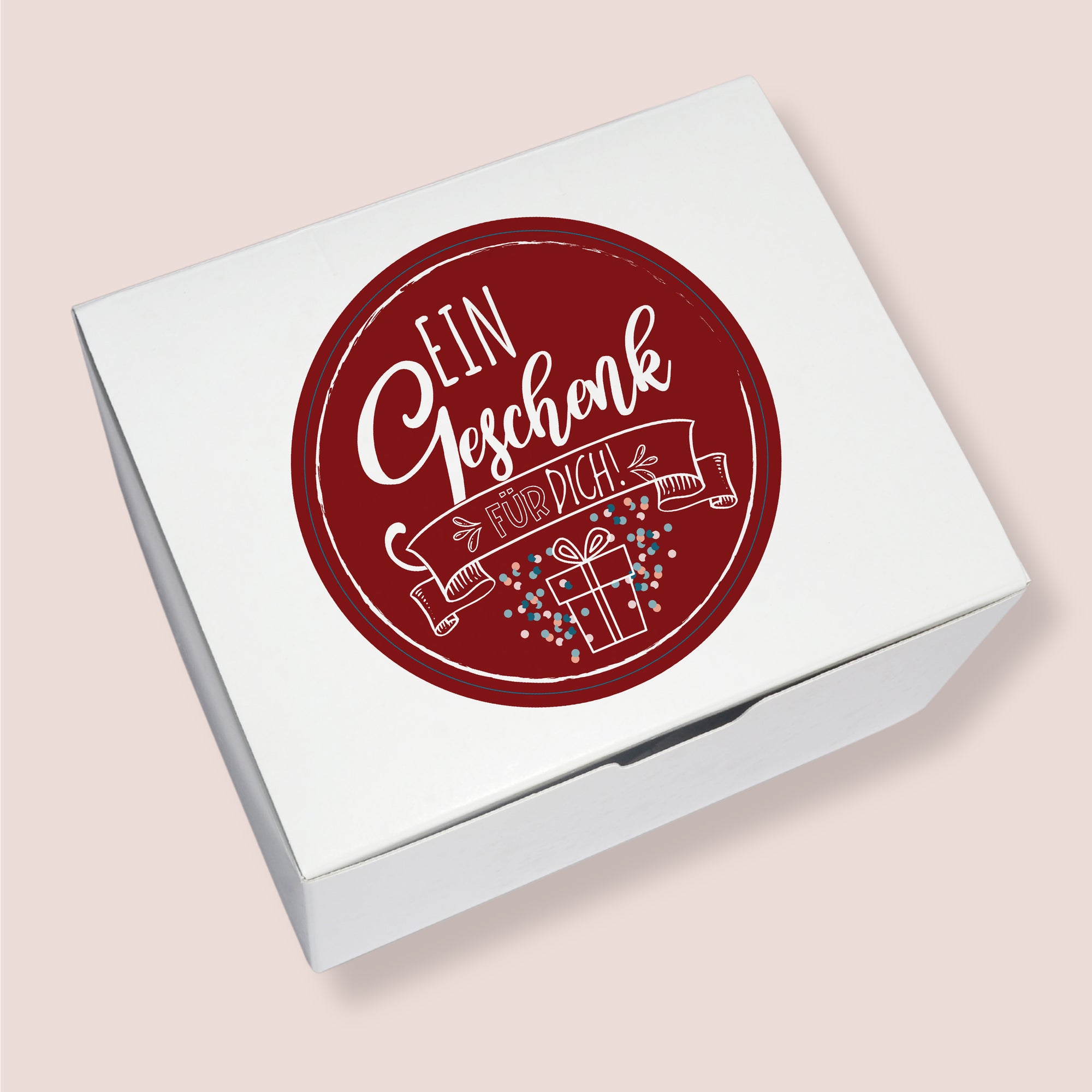 Geschenkbox mit rotem Aufkleber „Ein Geschenk für dich“