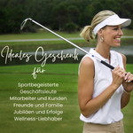 Golferin mit Golfschläger auf grünem Platz, sportlich gekleidet.
