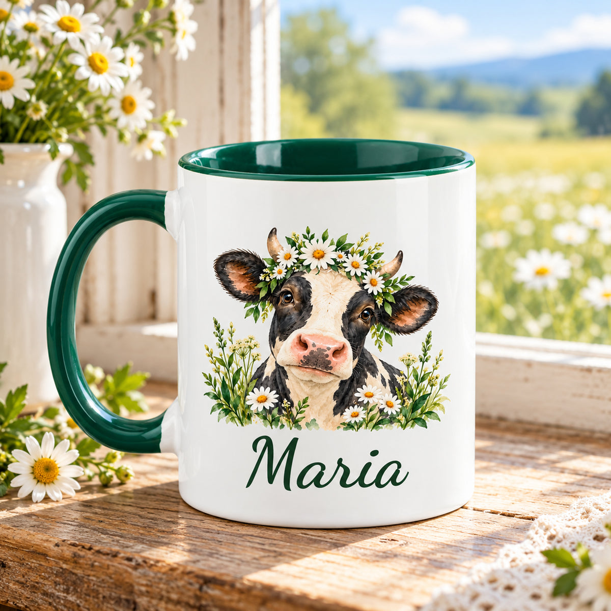 Kuh-Tasse mit schwarz-weißer Kuh mit Gänseblümchenkranz und Wunschname mit Henkel links, gegenüberliegende Druckseite im Grünen