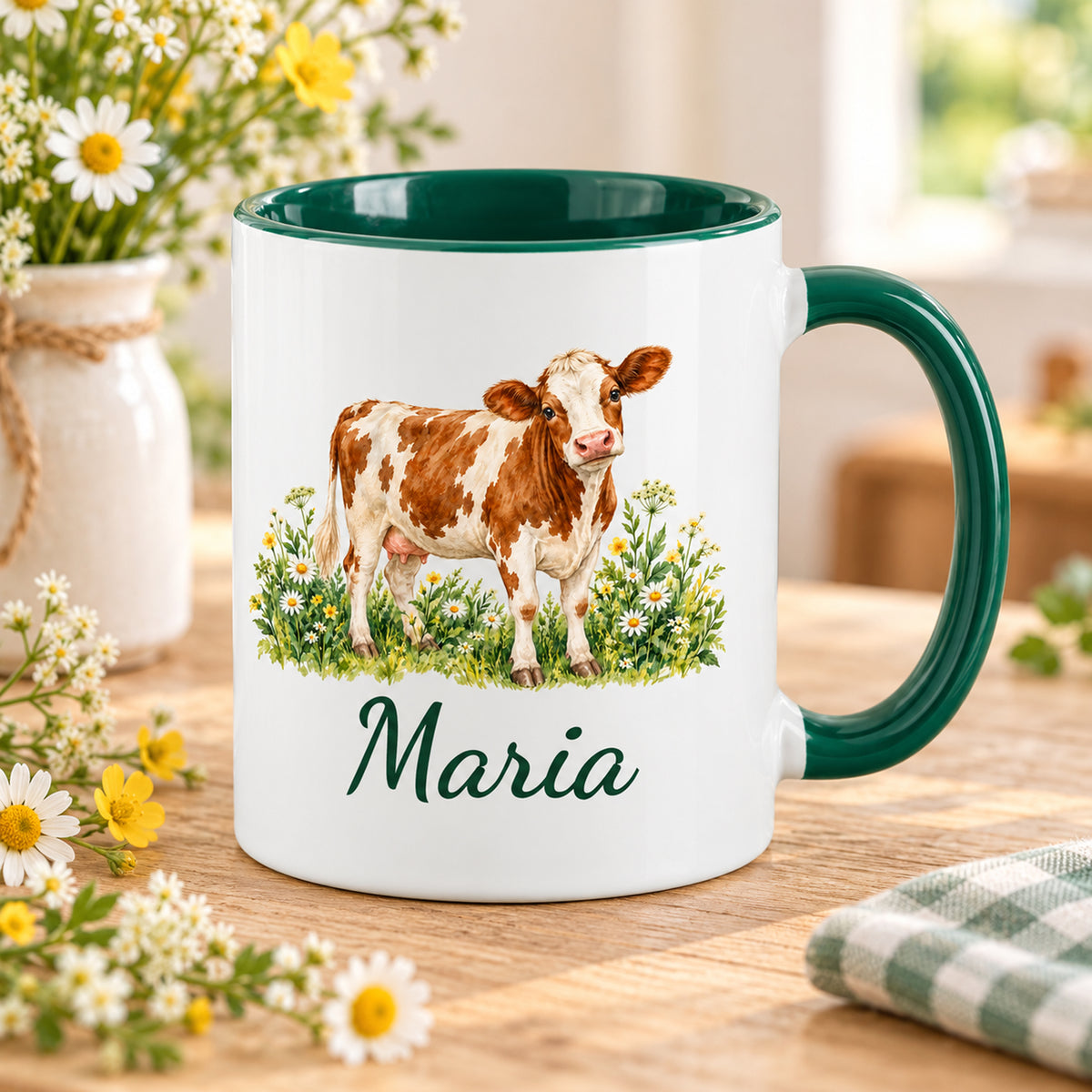 Kuh-Tasse mit braun-weißer Kuh zwischen Wildblumen und Wunschname auf einem Holztisch mit Wiesenblumen