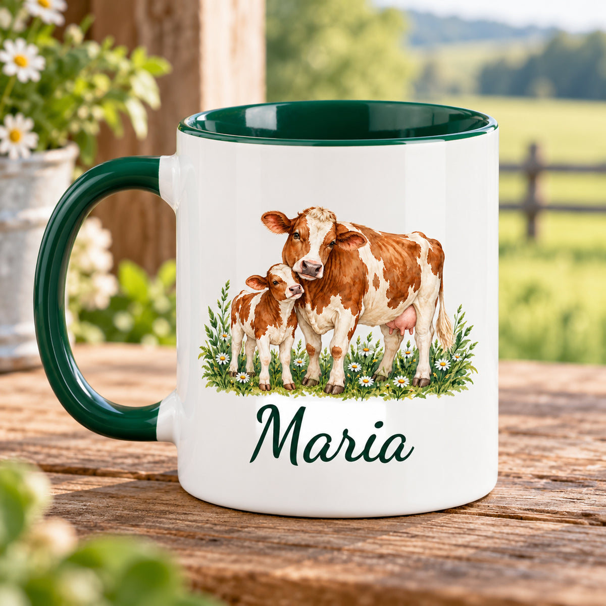 Kuh-Tasse mit braun-weißer Kuh und Kälbchen zwischen Wiesenblumen und Wunschname mit Henkel links, gegenüberliegende Druckseite im Grünen