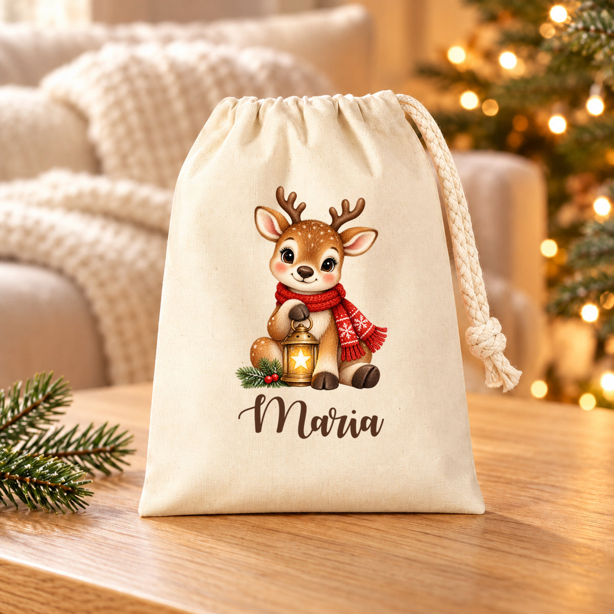 Naturfarbenes Nikolaussäckchen mit Rentier mit Sternenlaterne und personalisiertem Namen auf einem Holztisch vor Sofa und Weihnachtslichtern.