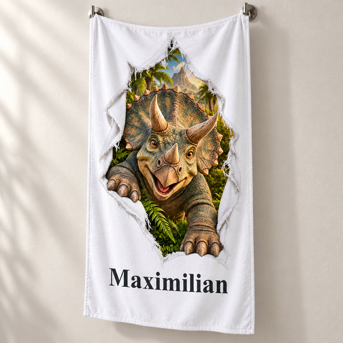Weißes personalisiertes Handtuch mit Triceratops-Motiv im Stoffriss-Design in schräger Studioansicht mit sichtbarem Saum.
