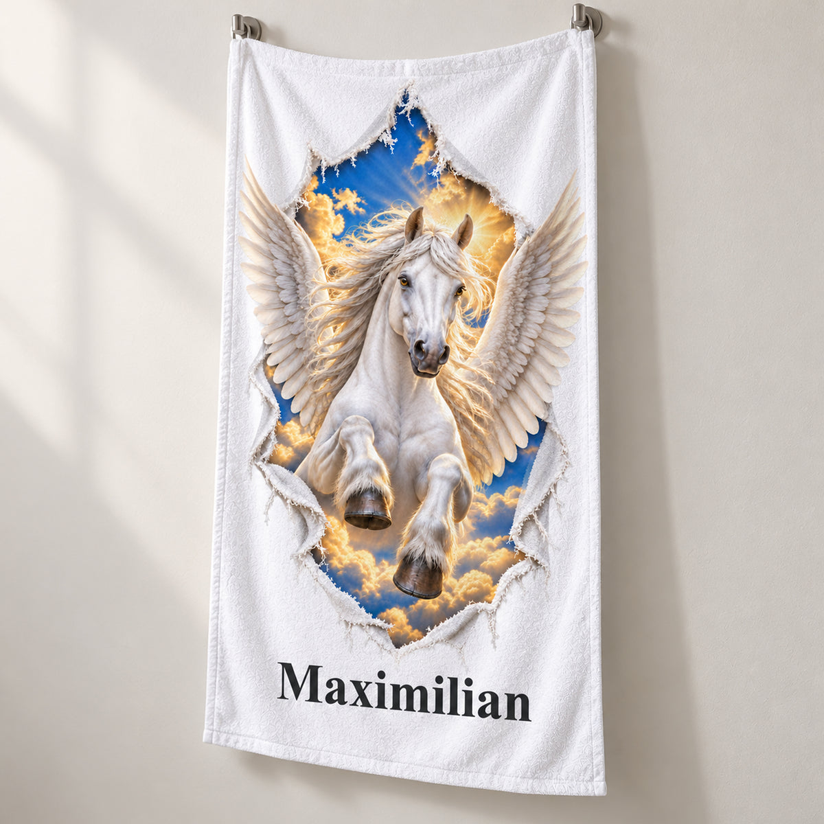 Weißes personalisiertes Handtuch mit Pegasus-Motiv im Stoffriss-Design in schräger Studioansicht mit sichtbarem Saum.