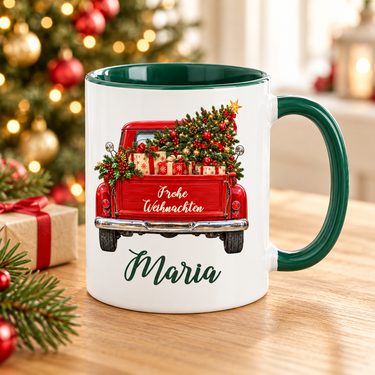 Weiß-grüne Weihnachtstasse mit rotem Truck, Motiv Tannenbaum und Geschenke, Weihnachtsgruß und einem Namen in grüner Schreibschrift auf einem Tisch in einer warmen weihnachtlichen Umgebung.