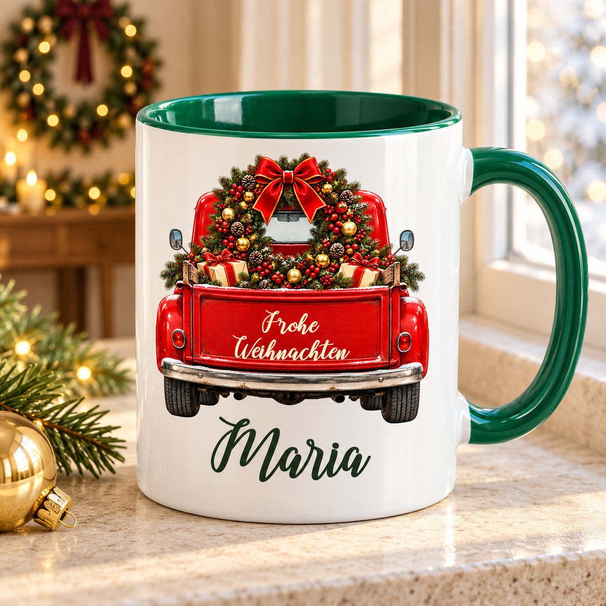 Weiß-grüne Weihnachtstasse mit rotem Truck, Motiv Weihnachtskranz, Weihnachtsgruß und einem Namen in grüner Schreibschrift auf einem Tisch in einer warmen weihnachtlichen Umgebung.
